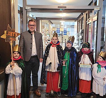 Dritter Bürgermeister Thomas Hofschuster mit den Sternsingern im Eingang des Rathauses.