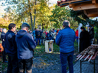 Die Besucherinnen und Besucher bei der Einweihung des Backhauses durch die beiden Pfarrer