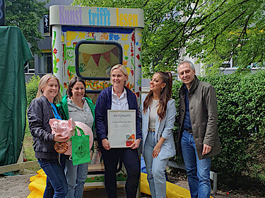 Gruppenbild vor der bunt bemalten Büchertauschzelle Gruppenbild vor der bunt bemalten Büchertauschzelle
