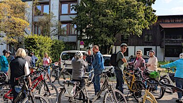 Einige Fahrräder und Radler:innen vor dem Puchheimer Rathaus