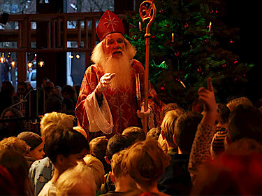 Nikolaus im Kostüm mit vielen Kindern vor einem Weihnachtsbaum Nikolaus im Kostüm mit vielen Kindern vor einem Weihnachtsbaum