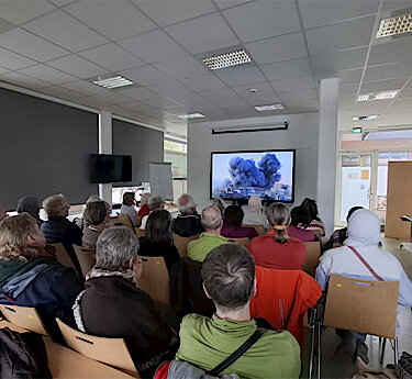 Besucher sitzen vor der Leinwand Besucher sitzen vor der Leinwand
